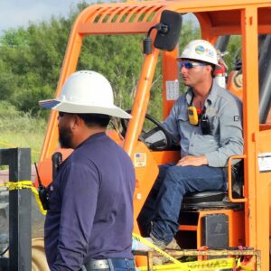 Telehandler operator on location wearing an AXS Monitor Mate, gas monitor at chest height